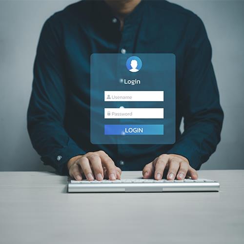 A Man Typing on a Keyboard with a Login Screen for the Best Banks For Free Checking Accounts.