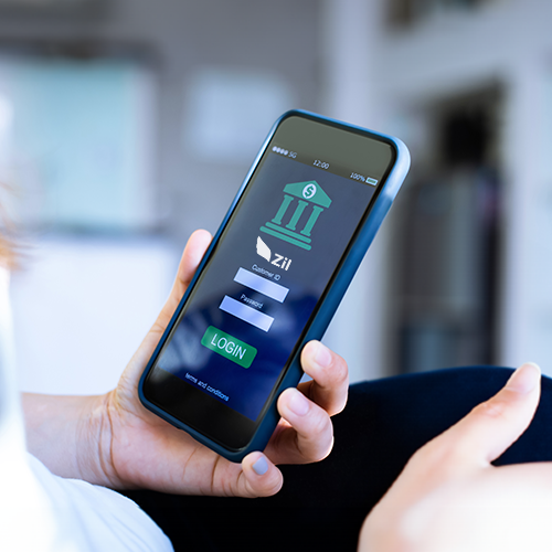 A Woman Holding a Cell Phone. She Is Looking for How to Do Bank Transfer