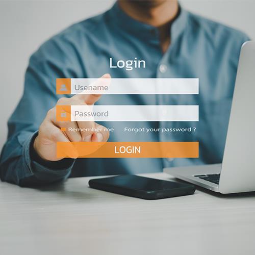 Image of a Man Pointing at a Login Screen on a Laptop, Highlighting the Process to Open A Small Business Bank Account Online