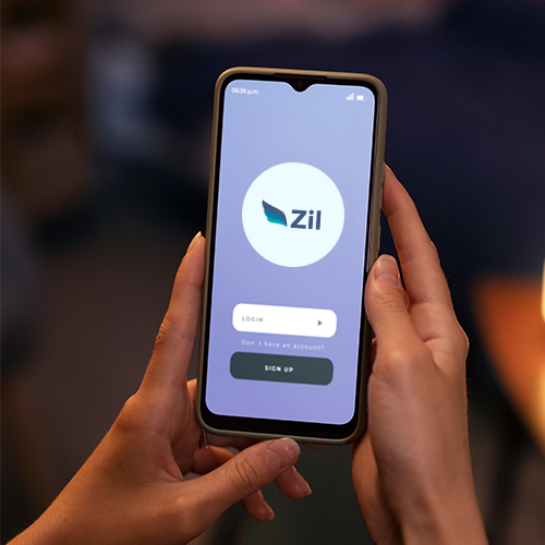 Hands Holding a Smartphone Displaying a Login Screen of Zil for Online Business Checking Account