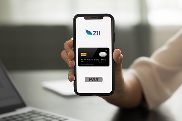 A Person Is Holding a Smartphone, Displaying the Zil App Interface with a Digital Representation of a Virtual Card